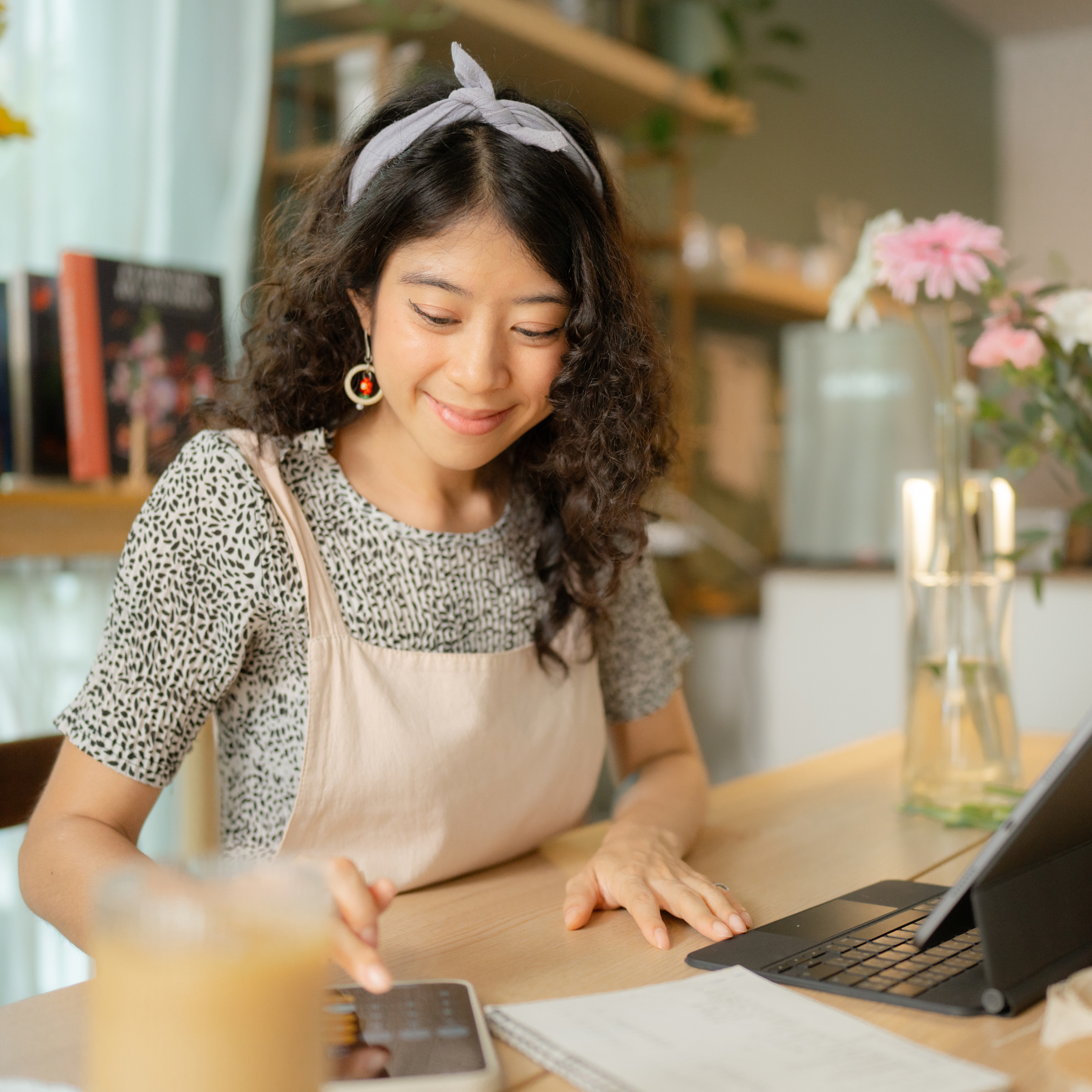 Woman sat at a desk using a laptop and calculator