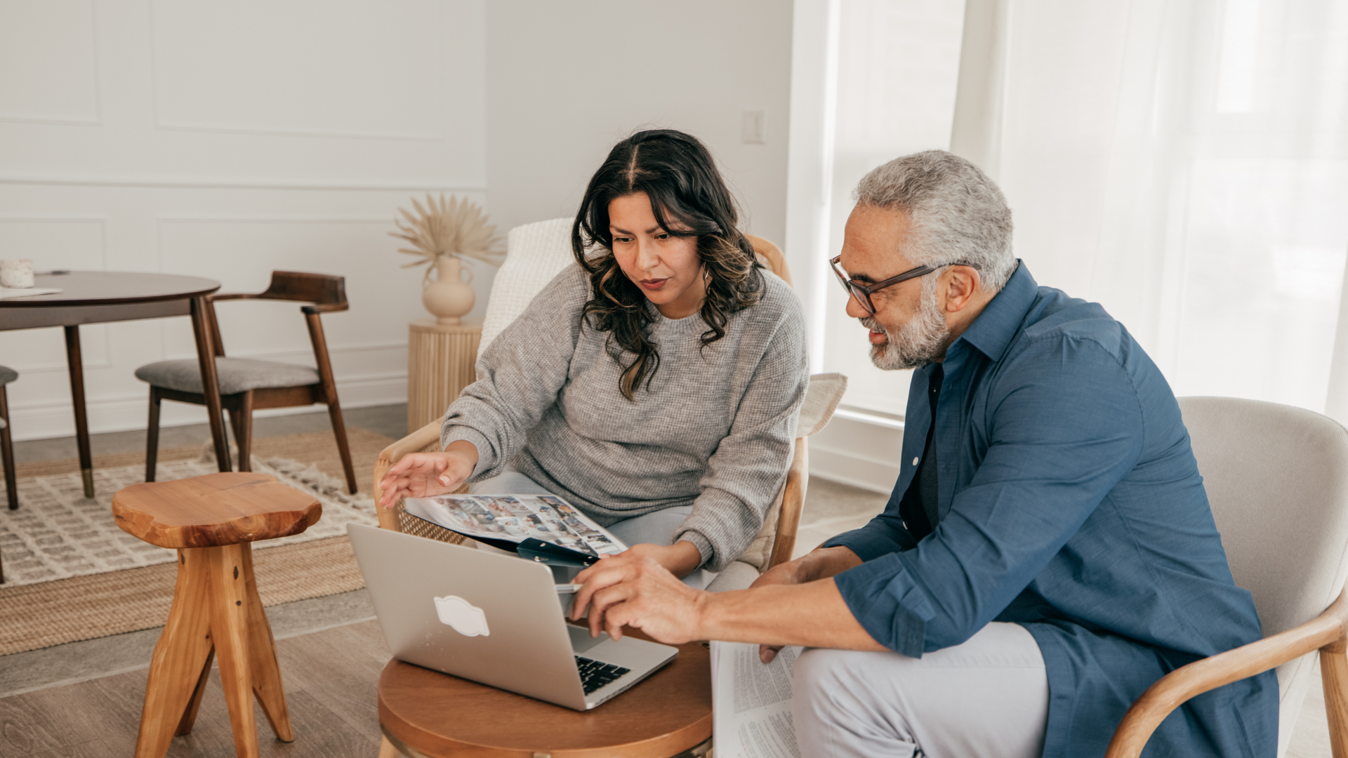 Woman and man sat looking at laptop and paperwork