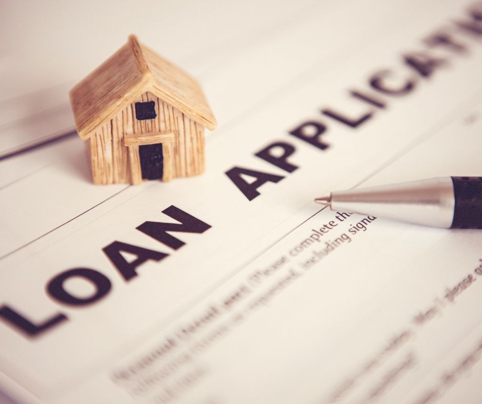 Loan application with pen and model house